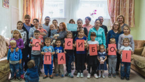Russian families holding up "thank you" letters in Russian